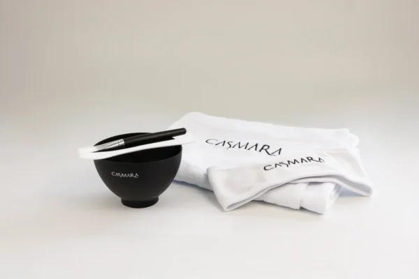 Casmara Mixing Kit with branded bowl, spatula, and folded 30x30 cm towel arranged for algae peel-off mask preparation.